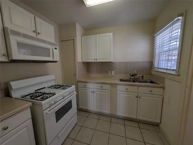 a kitchen with granite countertop cabinets stainless steel appliances and a sink