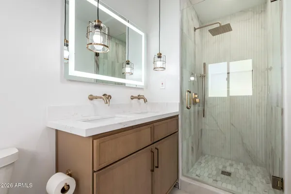 a bathroom with a sink mirror and a shower