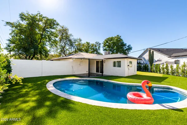 a swimming pool with yard in front of it