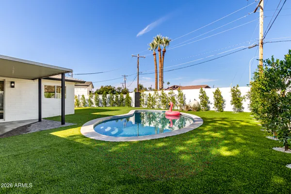 a view of a backyard with table and chairs potted plants