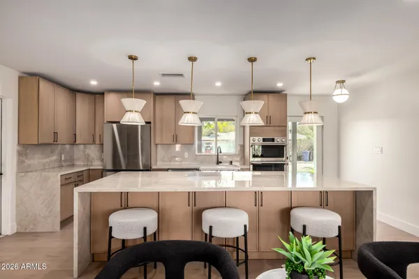 a kitchen with stainless steel appliances granite countertop a table chairs in it and a counter top space