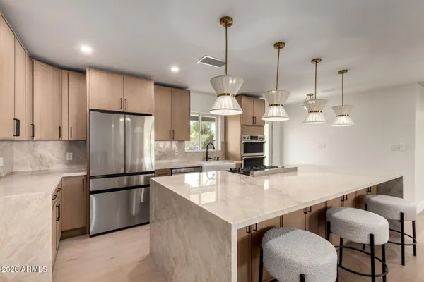 a kitchen with kitchen island a counter space a sink appliances and cabinets