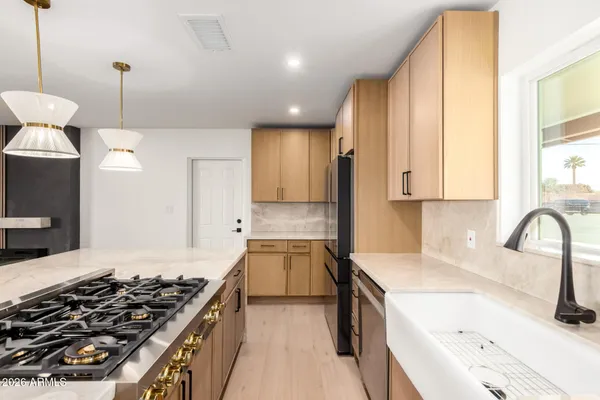 a kitchen with a stove a sink a refrigerator and a window