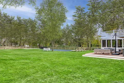 a view of a house with a big yard patio and swimming pool
