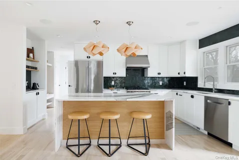 a kitchen with kitchen island granite countertop a stove a sink and a refrigerator