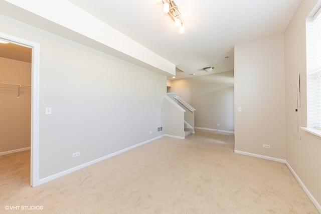 323 Aspen Pointe Road Vernon Hills, IL 60061 - Photo 2 of 12 an empty room with a ceiling fan and a window