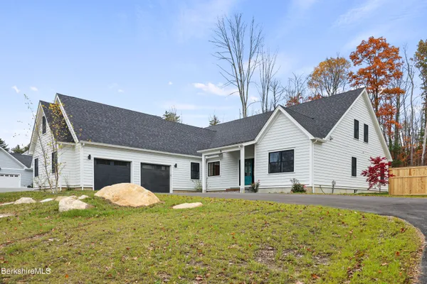 a front view of a house with a yard outdoor seating and garage