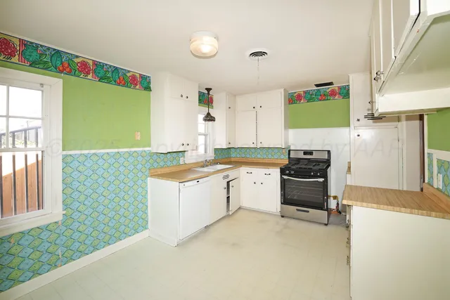a kitchen with a stove a refrigerator and a sink