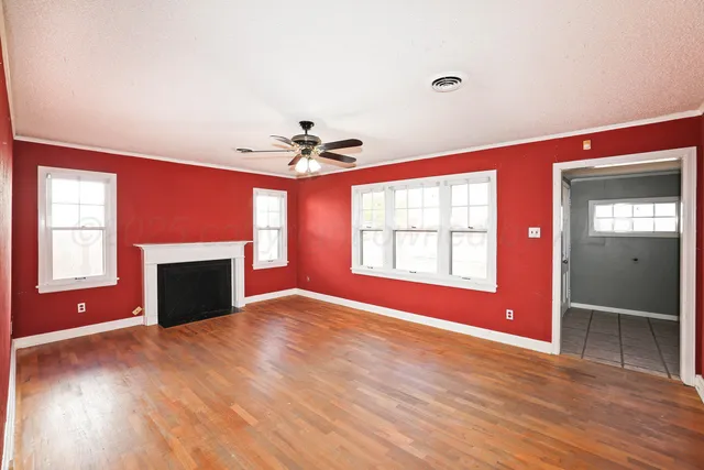a view of an empty room with a window and fireplace