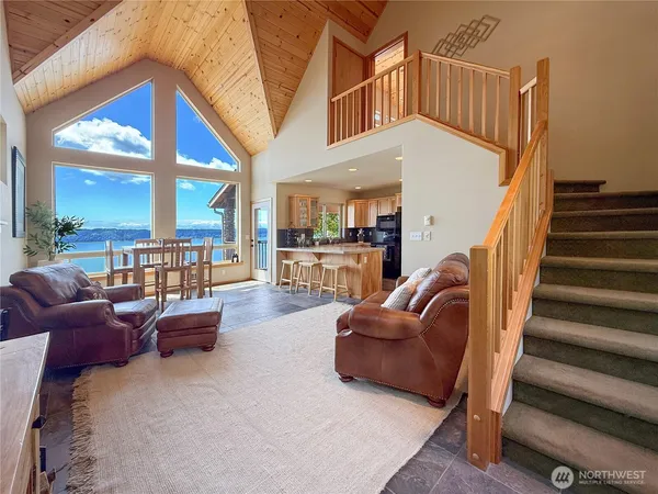 a living room with furniture a ceiling fan and a large window