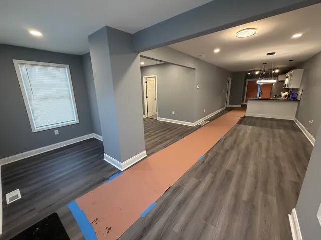 a view of an empty room with wooden floor