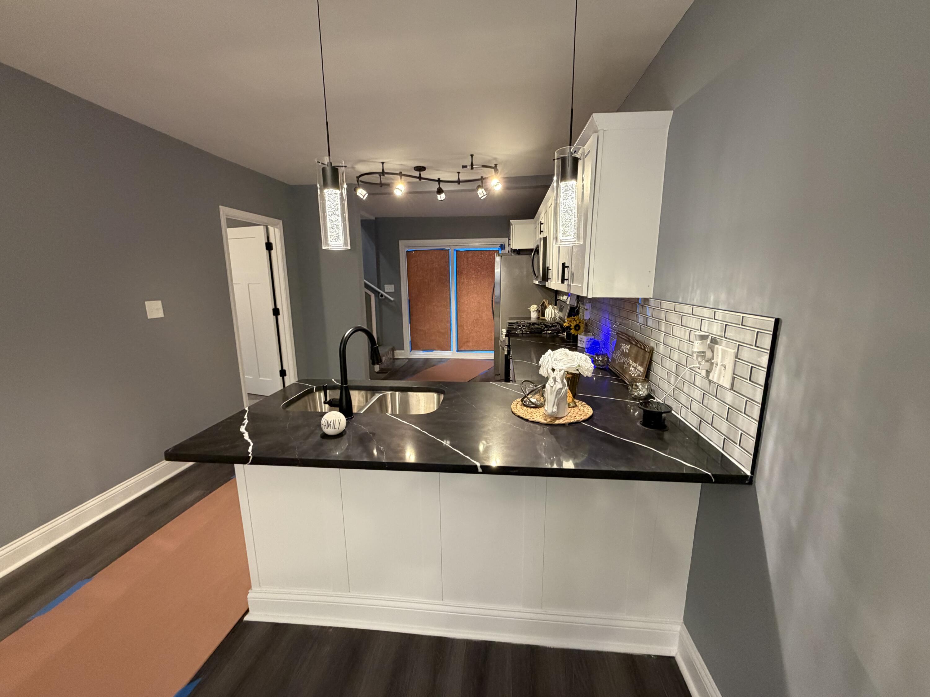 2425 Adams Street Gary, IN 46407 - Photo 6 of 26 a kitchen with kitchen island granite countertop a sink a counter top space and cabinets