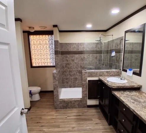 a bathroom with a granite countertop sink toilet and shower