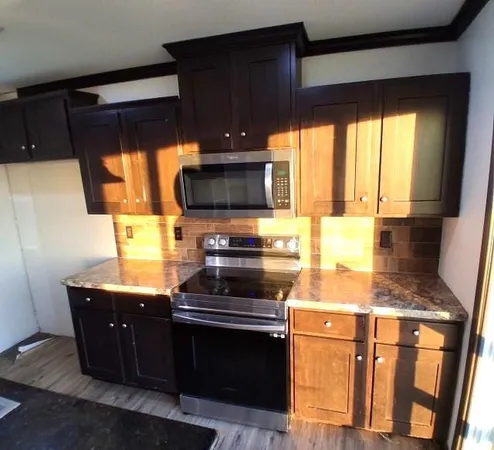 a kitchen with stainless steel appliances granite countertop a stove a sink and a microwave