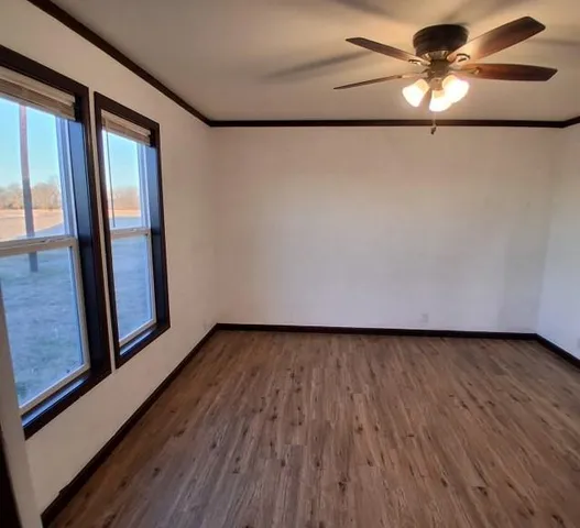 a view of a livingroom with wooden floor and a ceiling fan
