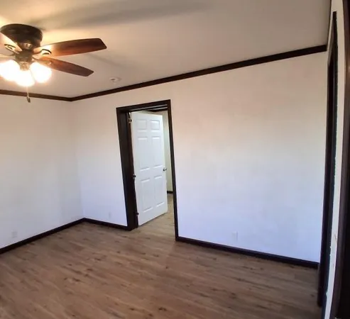 a view of an empty room with wooden floor