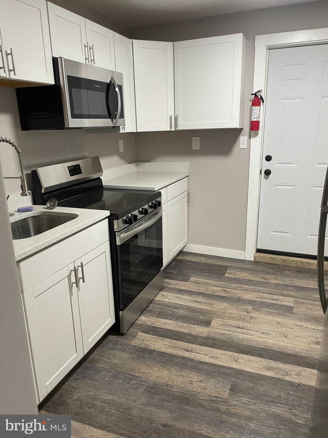 3137 Arbor Street Philadelphia, PA 19134 - Photo 4 of 17 a kitchen with white cabinets and white appliances