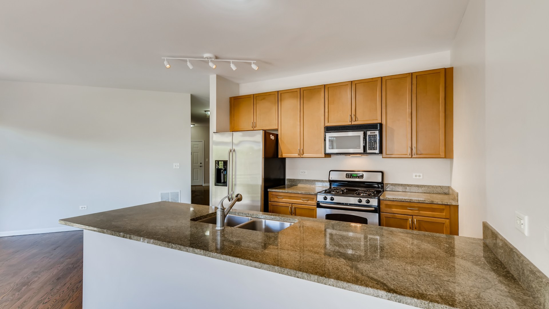 757 West 14th Place, Unit 2B Chicago, IL 60607 - Photo 15 of 32 a kitchen with a refrigerator a stove and a sink with wooden floor