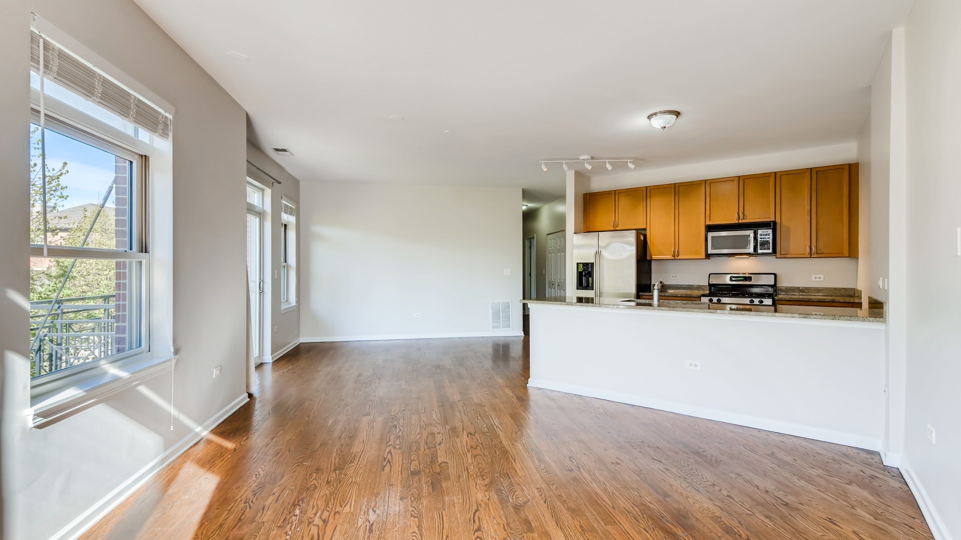 757 West 14th Place, Unit 2B Chicago, IL 60607 - Photo 7 of 32 a living room with stainless steel appliances wooden floors and a view of kitchen