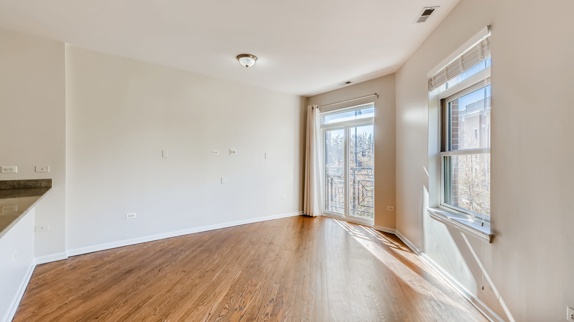 757 West 14th Place, Unit 2B Chicago, IL 60607 - Photo 9 of 32 a view of an empty room with wooden floor and a window