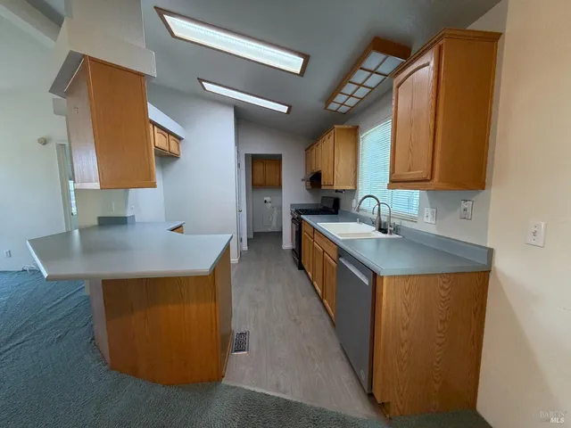 a kitchen with stainless steel appliances granite countertop a sink a stove and a refrigerator