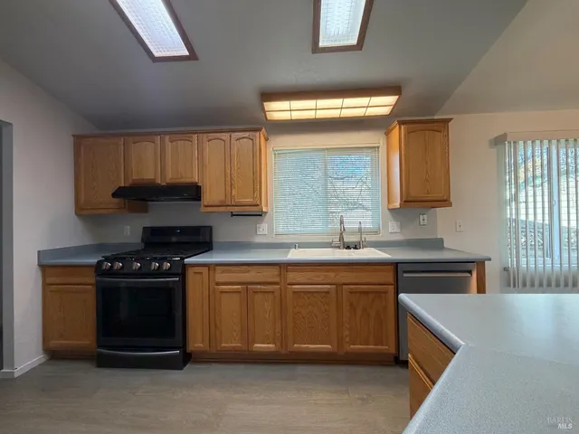 a kitchen with a stove and white cabinets