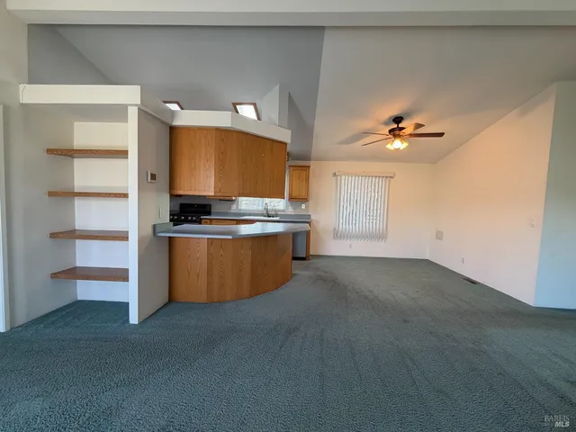 a kitchen with stainless steel appliances a stove a sink and a refrigerator with wooden floor