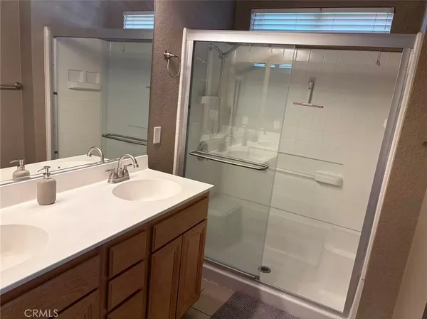 a bathroom with a shower sink and mirror