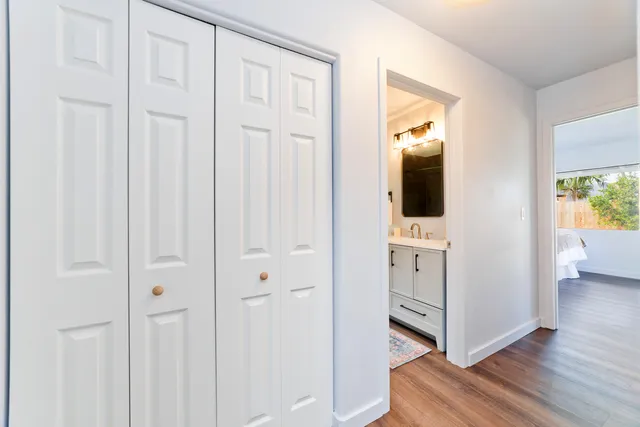a view of a hallway with wooden floor and closet