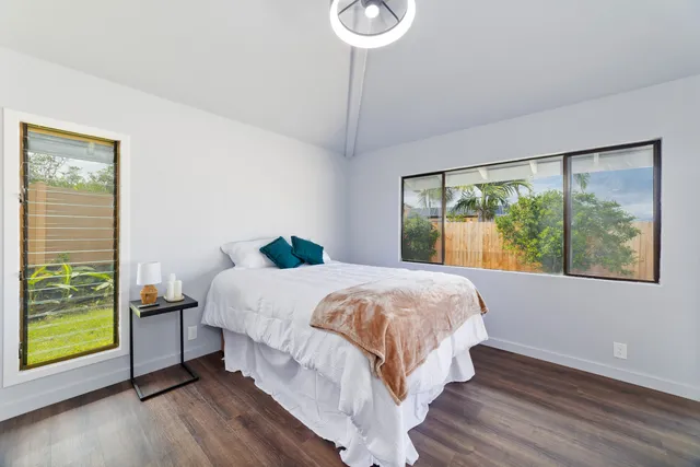 a bed sitting in a bedroom next to a window