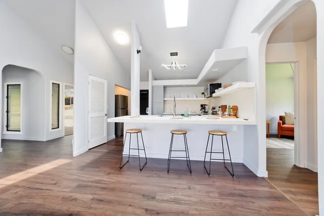 a kitchen with stainless steel appliances kitchen island granite countertop a table chairs and a refrigerator