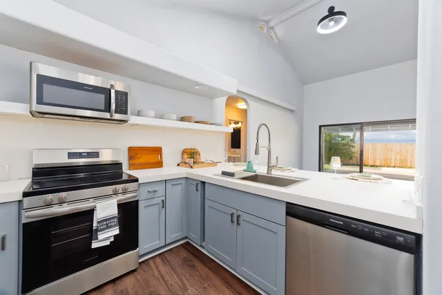 a kitchen with stainless steel appliances a stove sink and microwave