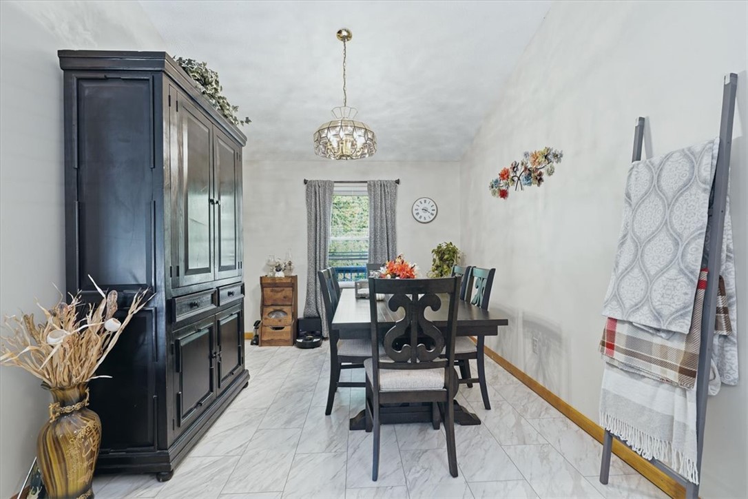 211 Cedar Ridge Drive Westminster, SC 29693 - Photo 7 of 34 Polished tile flooring and an elegant light fixture define this welcoming dining space.