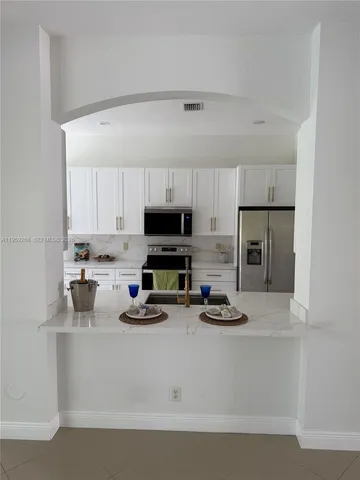 a view of open kitchen with furniture and refrigerator