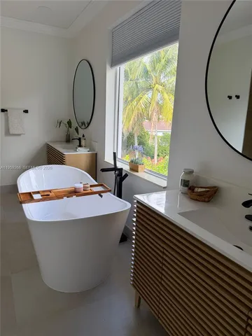 a view of a white house with a yard and potted plants