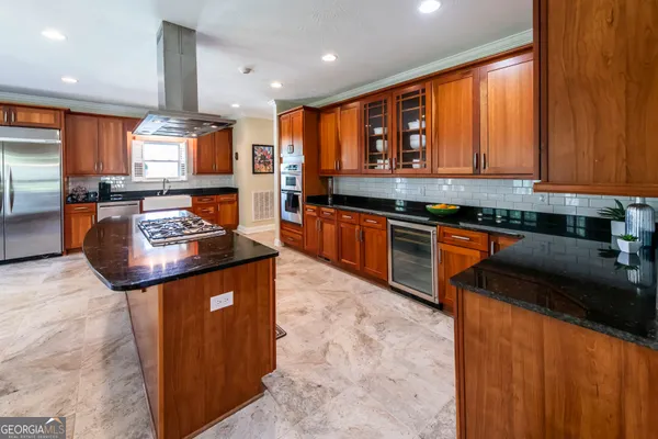 a kitchen with stainless steel appliances granite countertop sink stove top oven and cabinets