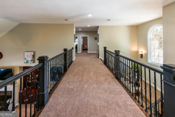 a view of a hallway with wooden floor and stairs