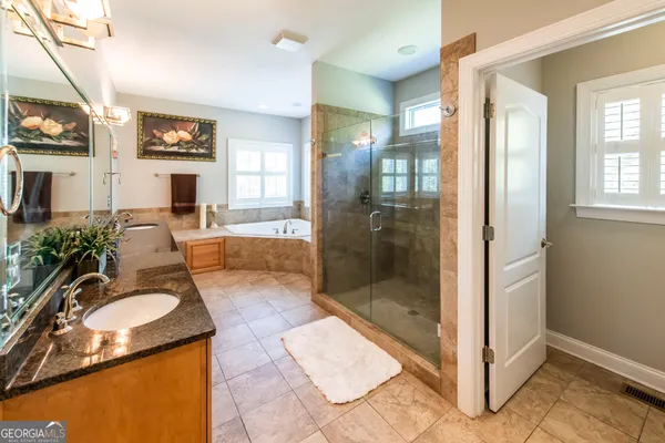 a spacious bathroom with a granite countertop tub sink and mirror