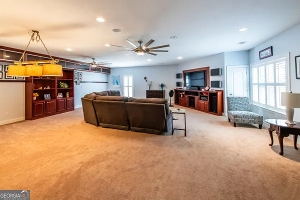 a living room with furniture a flat screen tv and kitchen view