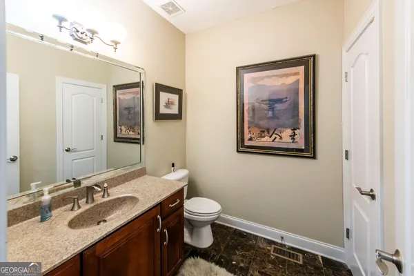 a bathroom with a granite countertop sink and a mirror