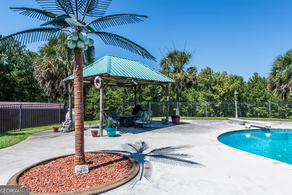 a swimming pool with barbeque oven and outdoor seating