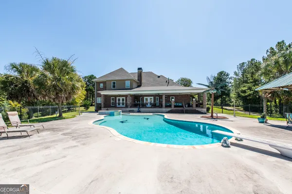 a view of a house with swimming pool and a yard