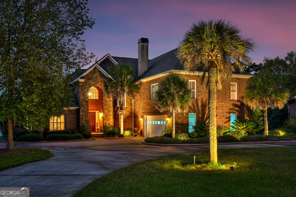 a front view of a house with yard and green space