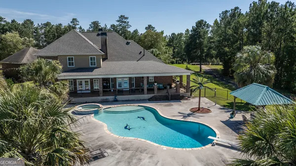 an aerial view of a house with swimming pool and patio