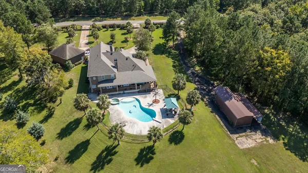 an aerial view of house with yard swimming pool and outdoor seating