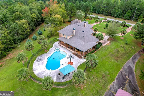 an aerial view of a house with a garden and swimming pool