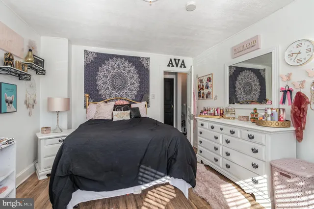 a bedroom with a bed and dresser with mirror