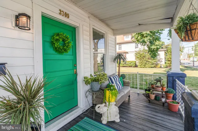 a view of a deck with couches floor to ceiling window and potted plants