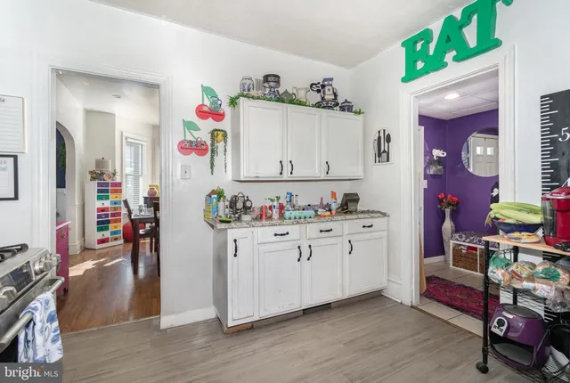 a room with kitchen island granite countertop lots of clutter and cabinets