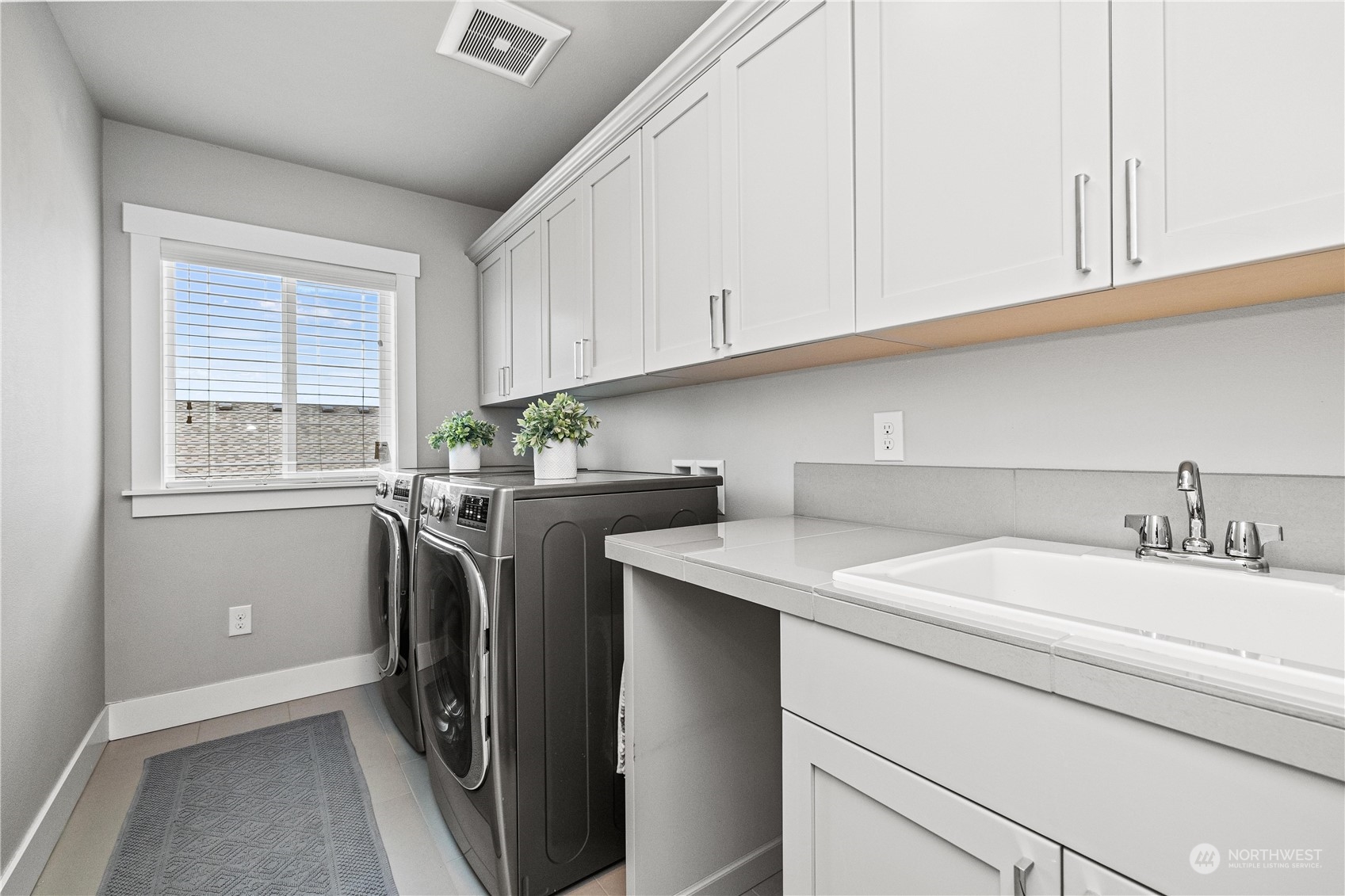 5764 Northeast 7th Court Renton, WA 98059 - Photo 24 of 40 a utility room with stainless steel appliances granite countertop a sink a washer and dryer with cabinets